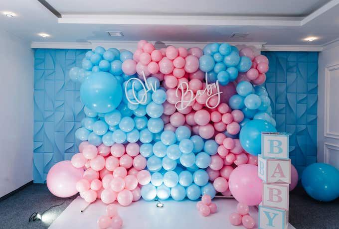 Dekoration med rosa och blå ballonger för en gender reveal-fest.